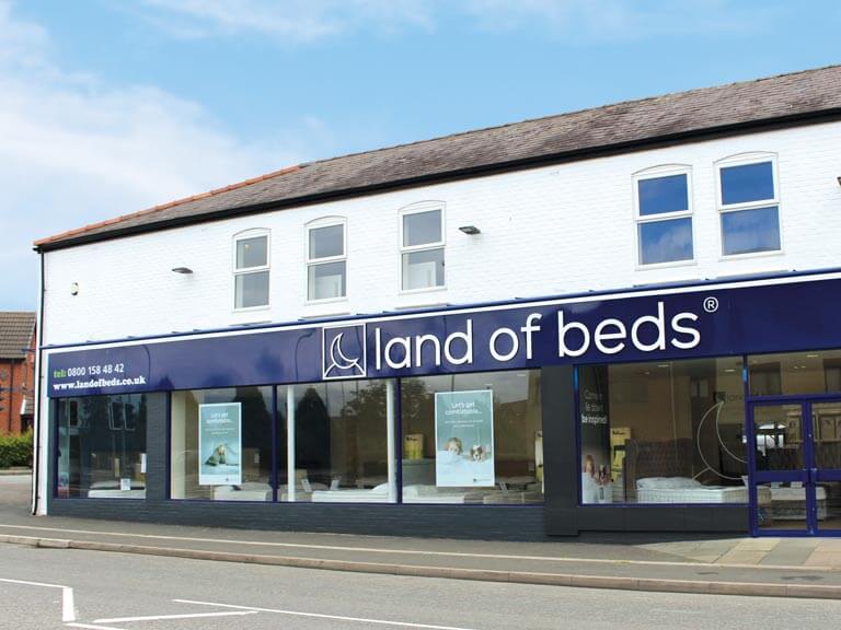 The front of the Land of Beds store in Cheshire. The storefront features large windows displaying various beds