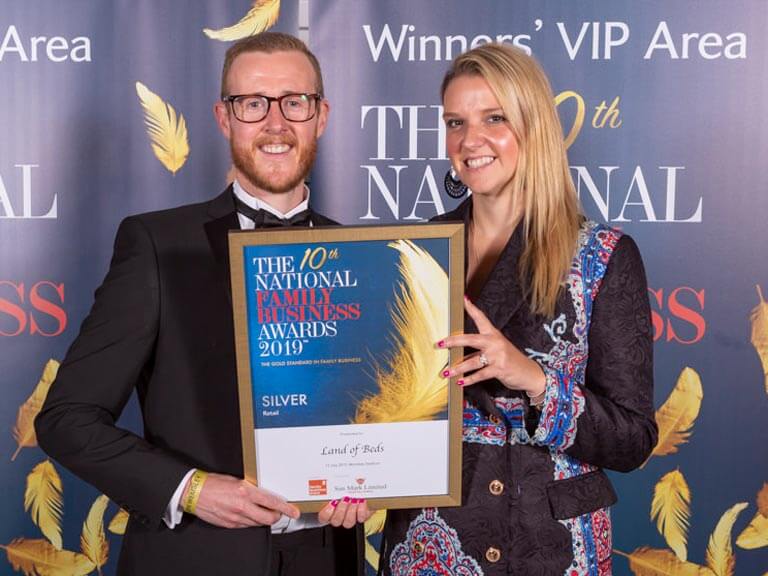 CEO & wife hold National Family Business Award. Smiling proudly