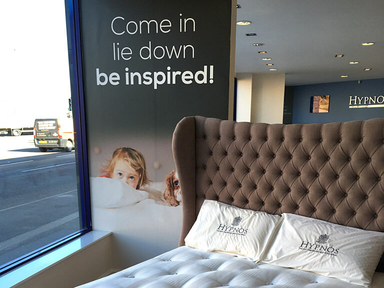 A Hypnos mattress on display with matching pillows
