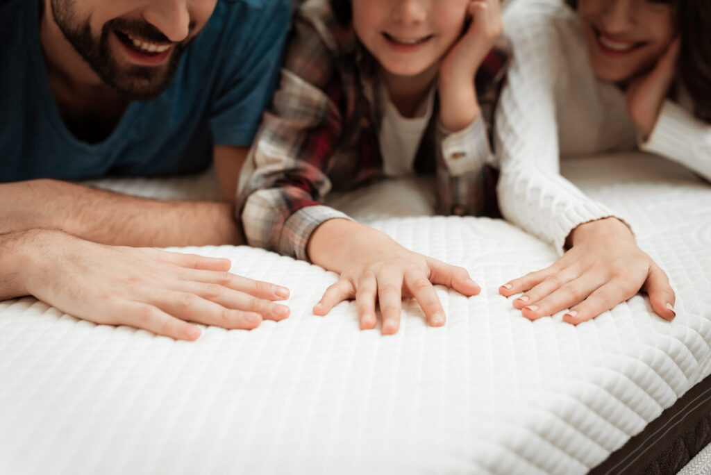 Close up of a Happy Family Touching a Mattress 