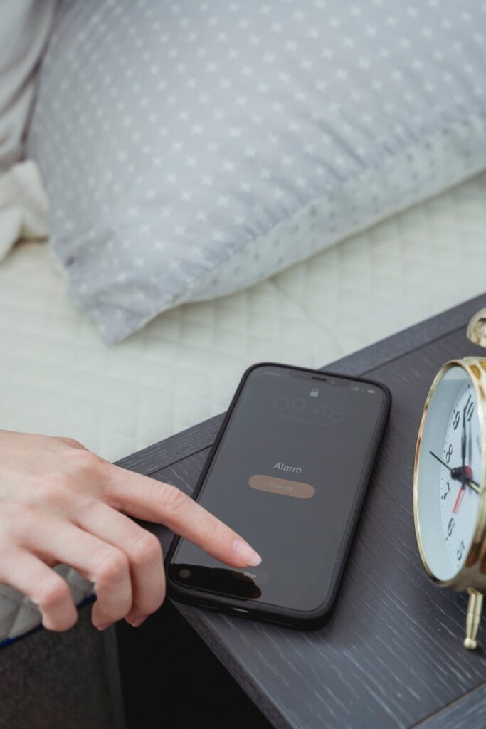 A woman hitting snooze on her phone's alarm as she was up all night unable to beat insomnia