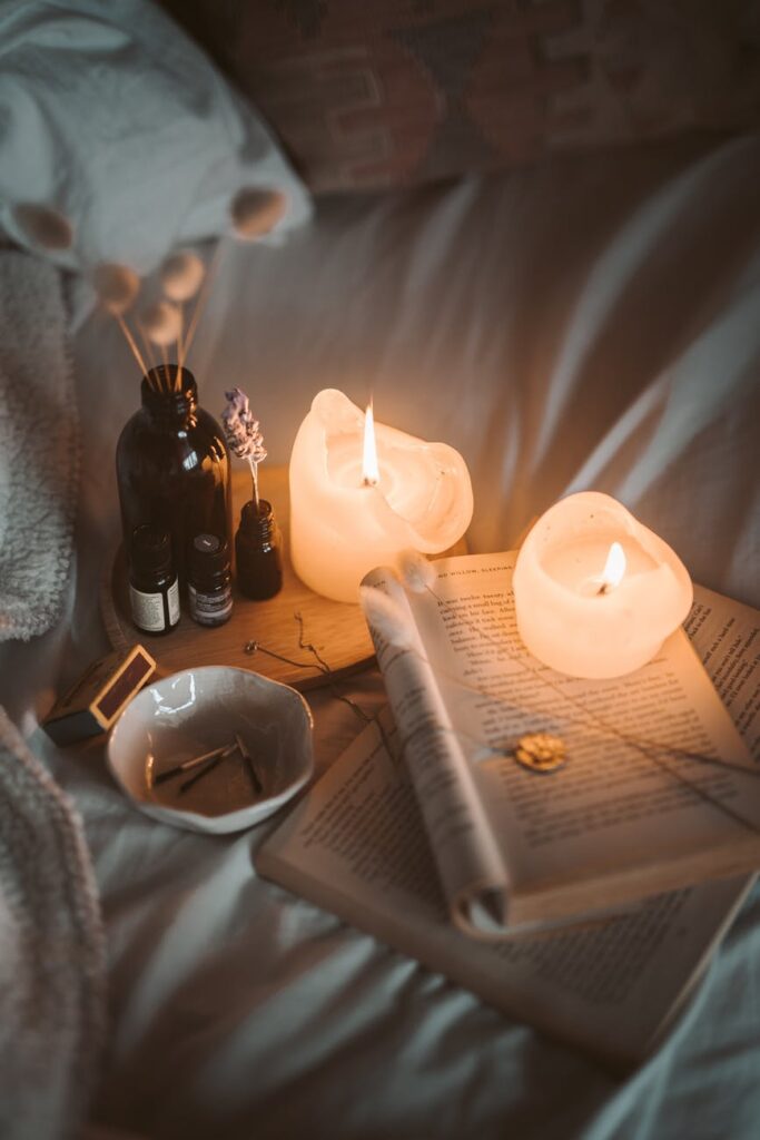 Open books and candles on a bed