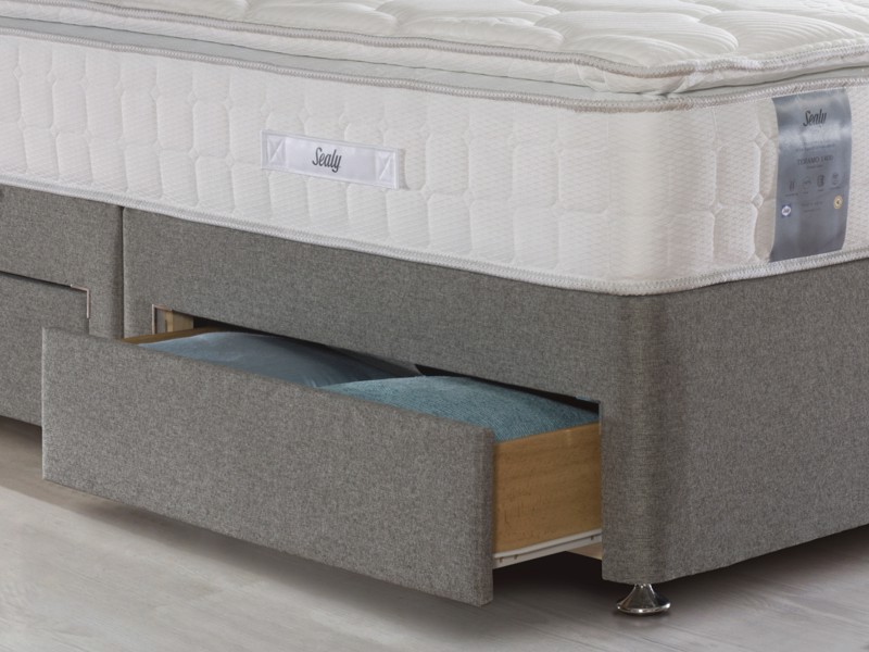 Close up of a divan bed with an open drawer
