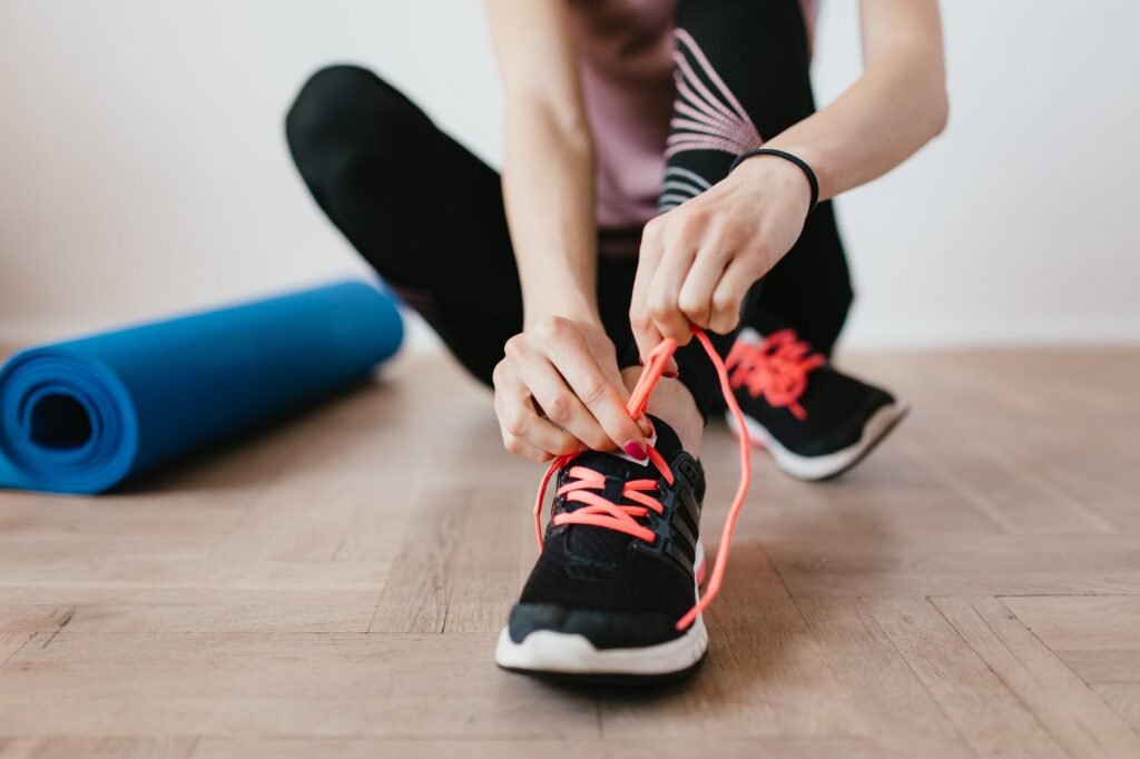 A woman tying laces on her trainers, ready for exercise to help beat insomnia