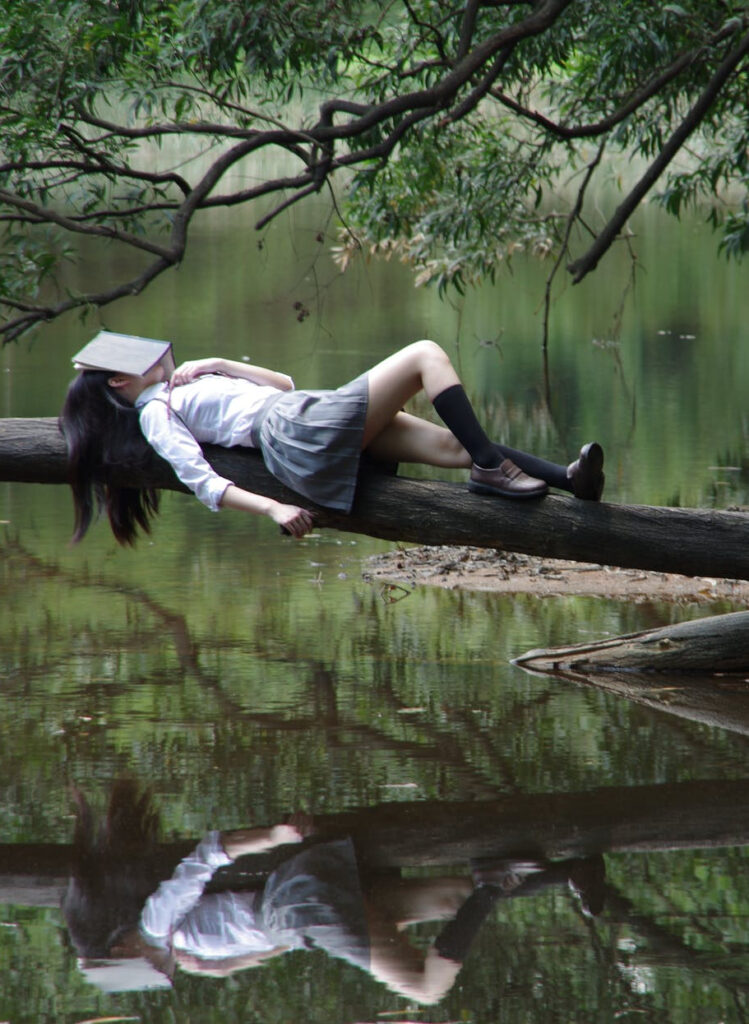 Girl napping on a tree in the afternoon as she isn't getting enough sleep in bed at night