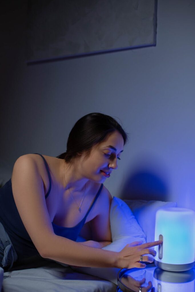 A woman using a special lighting device next to her bed in order to beat insomnia