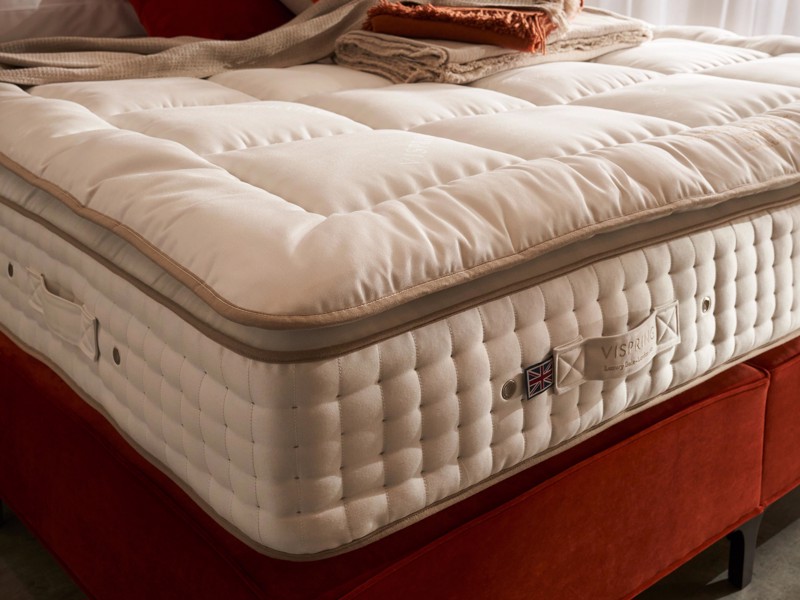 A mattress topper applied to a mattress on a red base bed