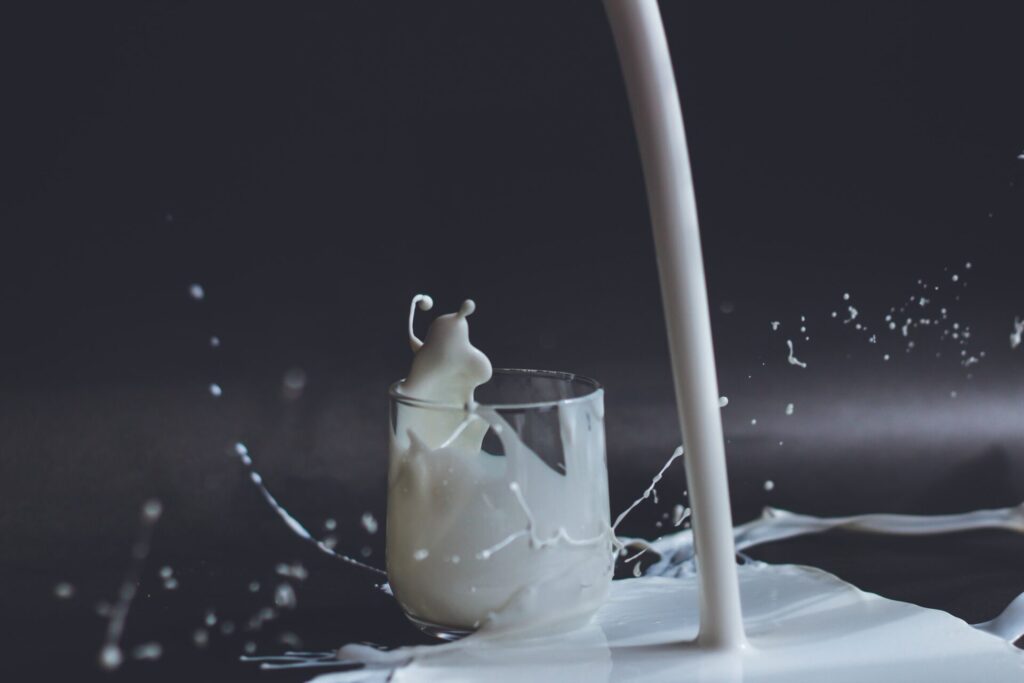 A misfire of milk being poured into a glass, making a mess