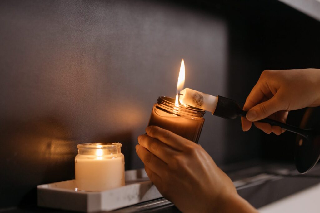 Close up of woman's hand holding a candle as she lights it