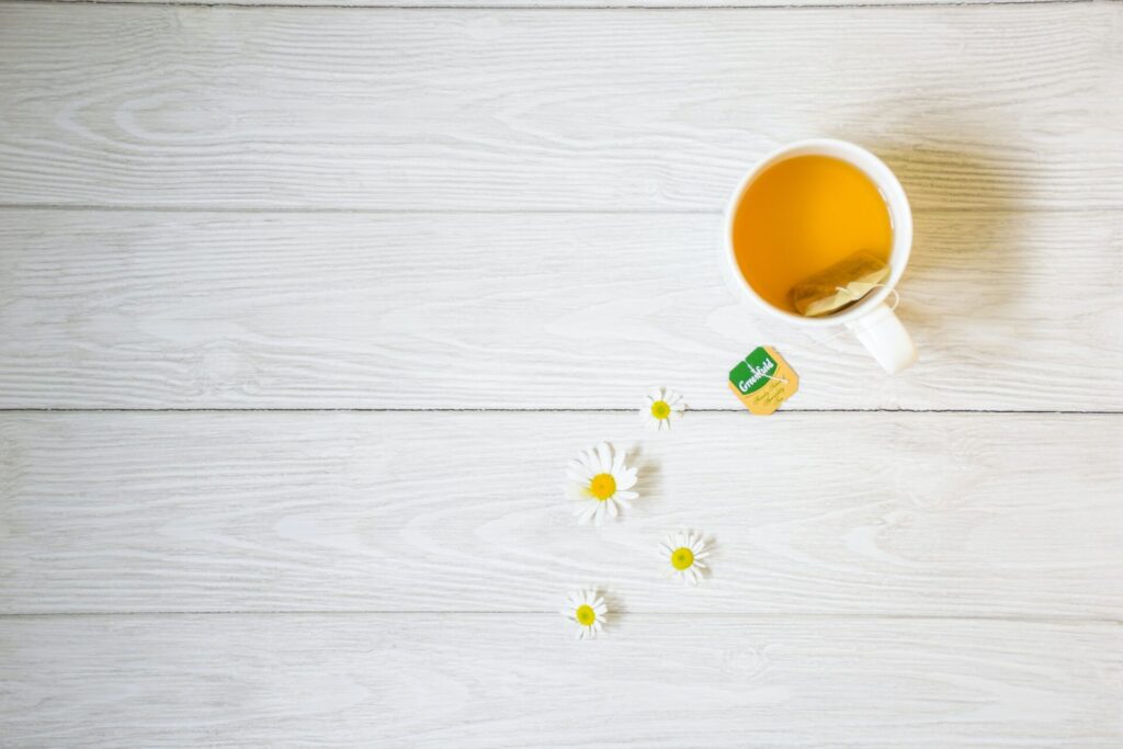 Cup of camomile tea on a table, as seen from above