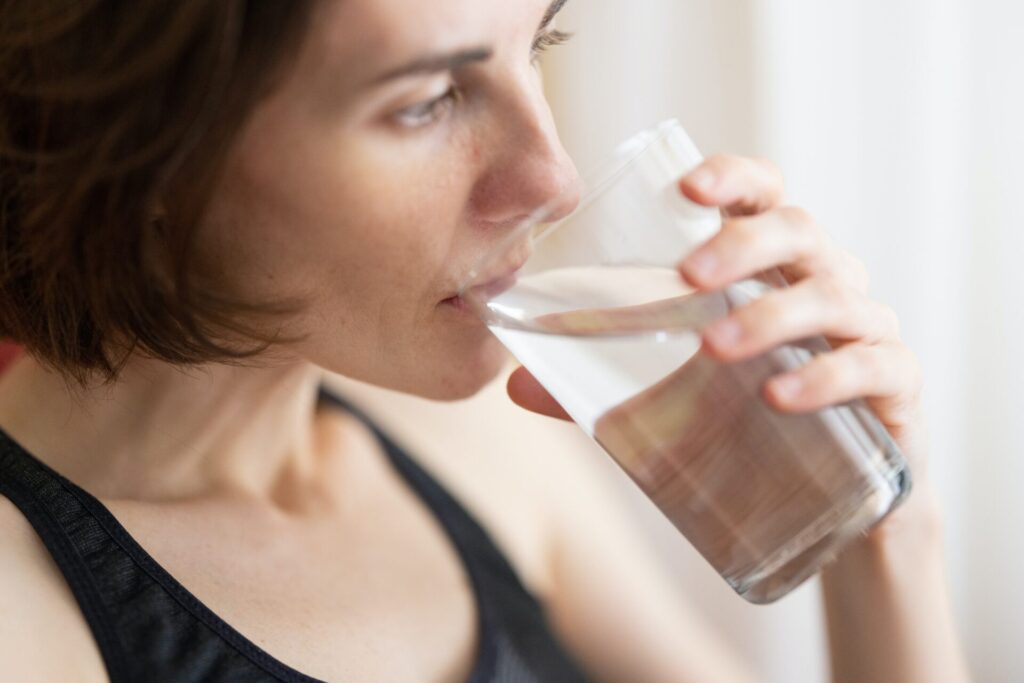A woman drinking from a glass of water