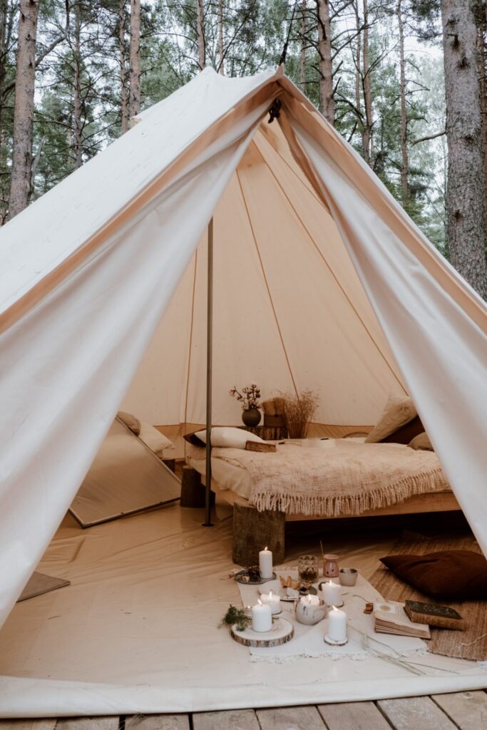 Cream coloured Hygge tent featuring low level bed and candles
