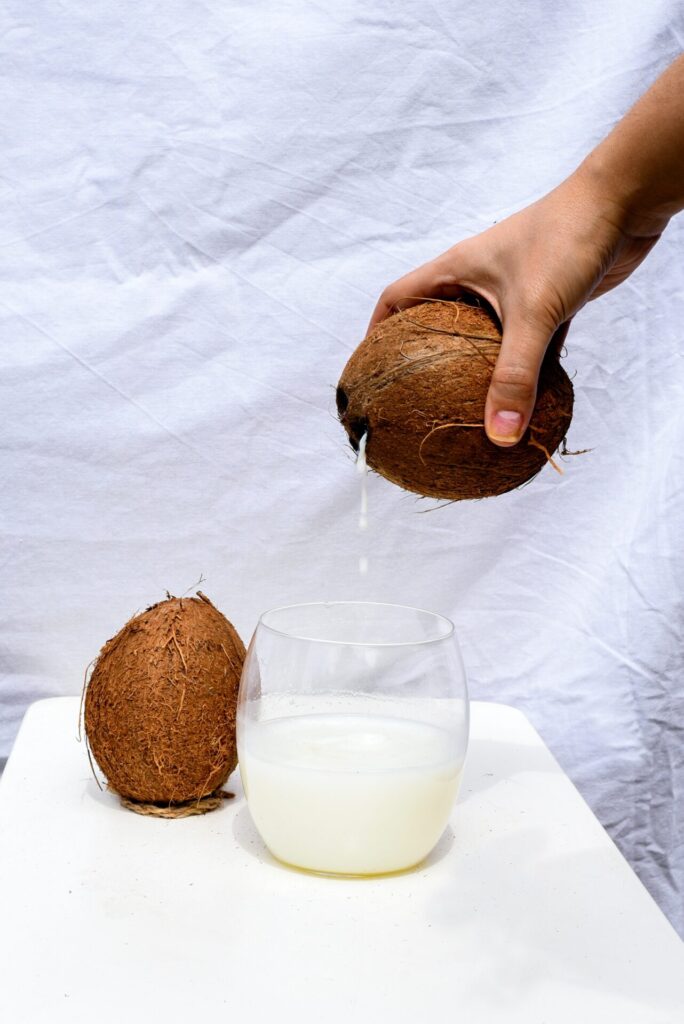 Pouring coconut water out of a coconut into a glass