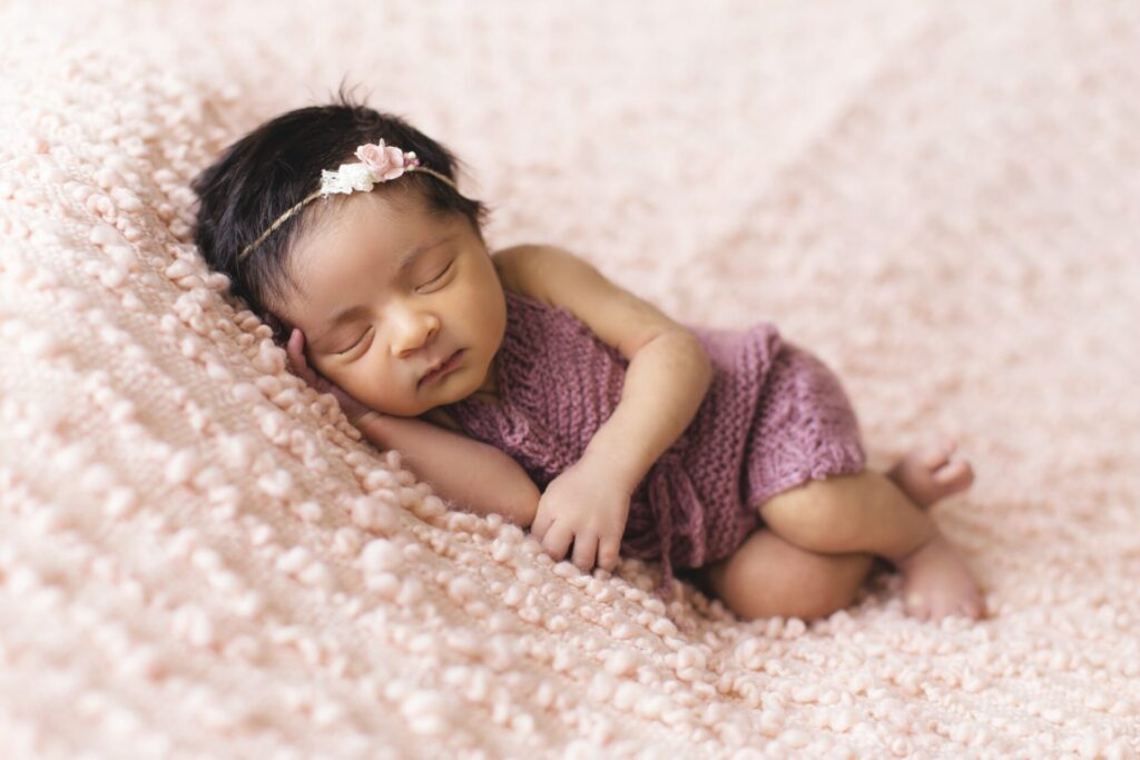Baby girl in pink knitted dress sleeping