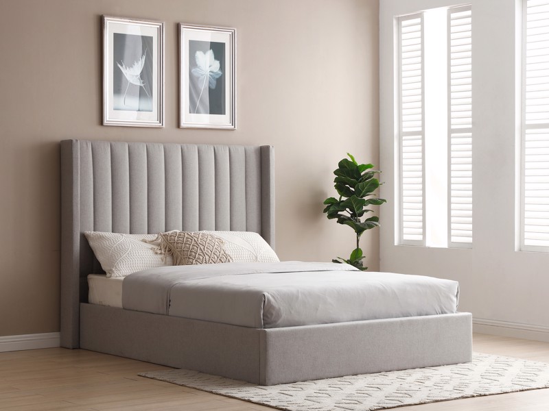 upholstered bed frame with tall headboard in light grey in a naturally lit bedroom