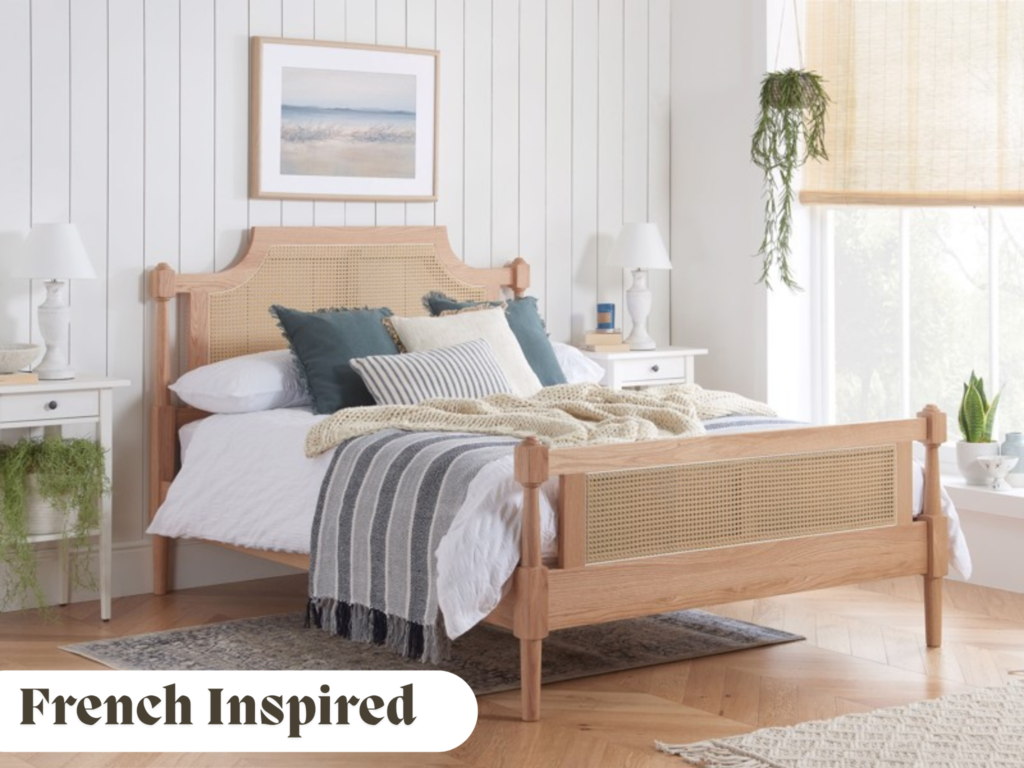 Rattan bed frame with white and blue bedding in a naturally lit room with plants 