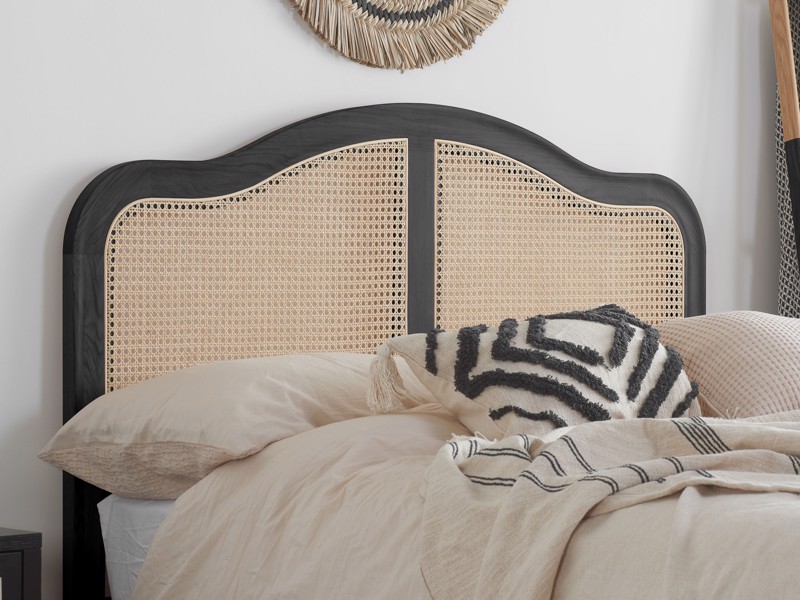 black rattan bed frame with cream bedding
