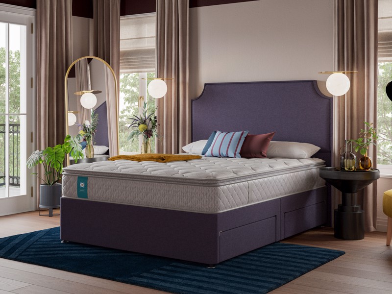 Upholstered divan bed with mattress, built-in storage drawers and modern bedroom styling with plants and warm neutral décor